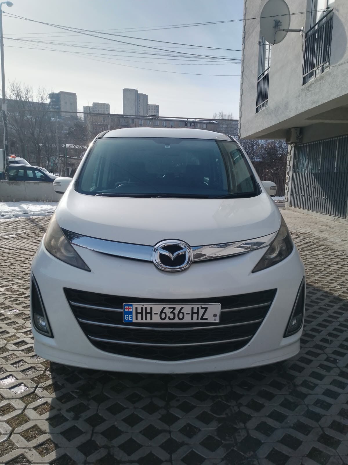 White Mazda minivan seen from the front